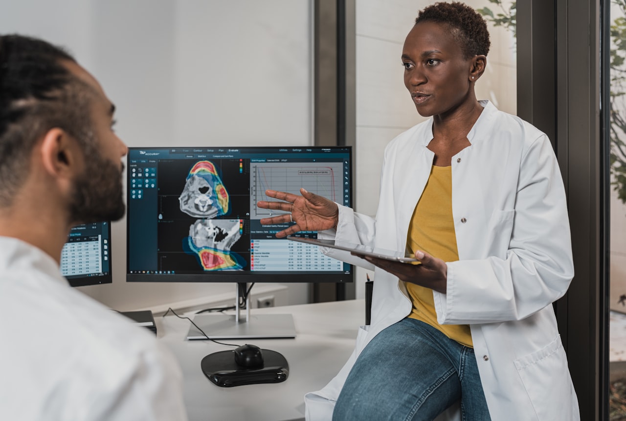 Two clinicians reviewing diagnostic imaging on a monitor